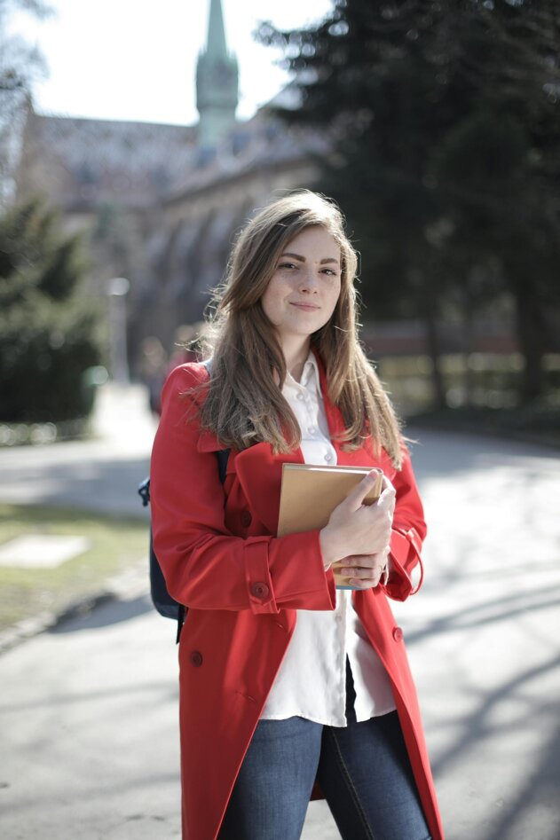 Learner holding books outdoors