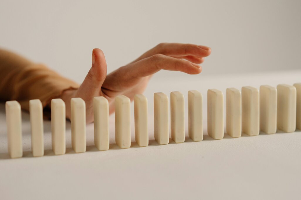 Hand preventing a chain of falling blocks